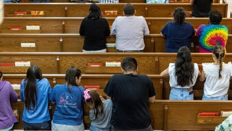 La gente reza en la Iglesia del Sagrado Corazón en Uvalde, Texas, después de que un hombre armado ingresara a la Escuela Primaria Robb y matara a varios niños y adultos.